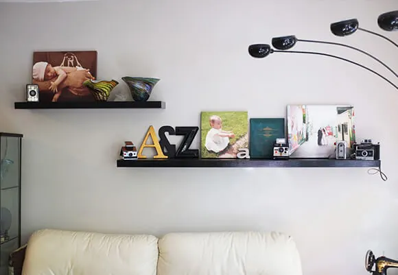 Gallery Prints on Shelves along with Candles and Figurines to make it Interesting